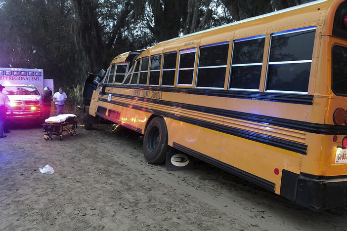 Authorities investigate the scene where a school bus crashed, Tuesday, Dec. 5, 2017, in Gum Branch, Ga. Liberty County Public Safety Director Mike Hodges said more than 20 children were riding the bus when it crashed into a tree during its morning route.