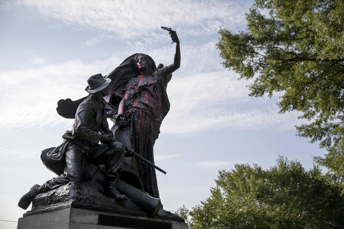 A statue depicting a Confederate soldier in Piedmont Park in Atlanta is vandalized with spray paint Monday, Aug. 14, 2017, from protesters who marched through the city last night to protest the weekend violence in Charlottesville, Virginia.