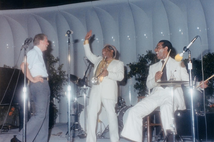 This photograph of President Jimmy Carter on stage at a White House jazz concert was taken on June 18, 1978. Carter appears in the photograph with trumpeter Dizzy Gillespie (center) and percussionist Max Roach (right).