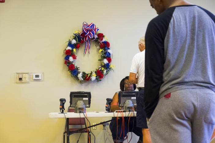 Checking ID against registration in Bibb County on primary day, May 22, 2018. 