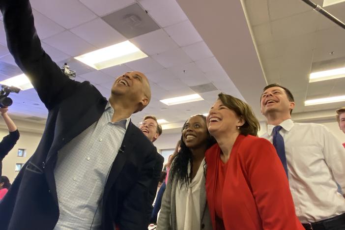 Sen. Cory Booker, Fair Fight Georgia's Esosa Osa, Sen. Amy Klobuchar and Mayor Pete Buttigieg smile for a selfie at a Fair Fight text bank contacting voters facing removal from Georgia's voter rolls.
