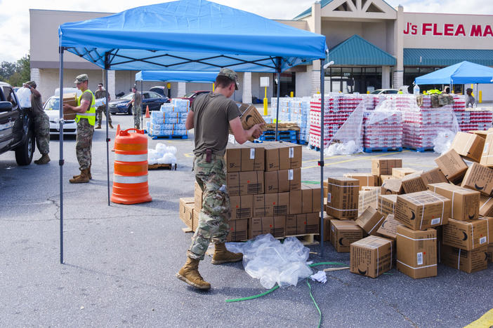 National Guard members hand out food in a vacant grocery store parking lot in Albany a week after Hurricane Michael.  