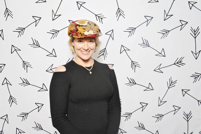 Host Rickey Bevington poses in the photo booth with a prop hat at the High Museum of Art's "First Friday" event.