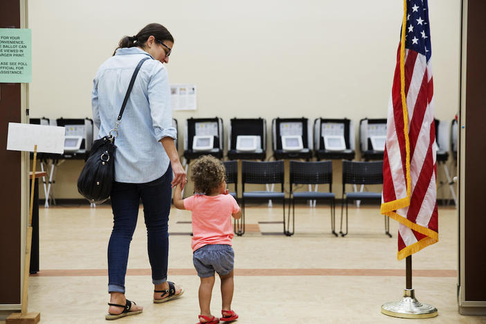 Melissa Painter walks with her one year-old daughter Elle to vote in Georgia's 6th Congressional District special election at a polling site in Sandy Springs, Ga., Tuesday, June 20, 2017.