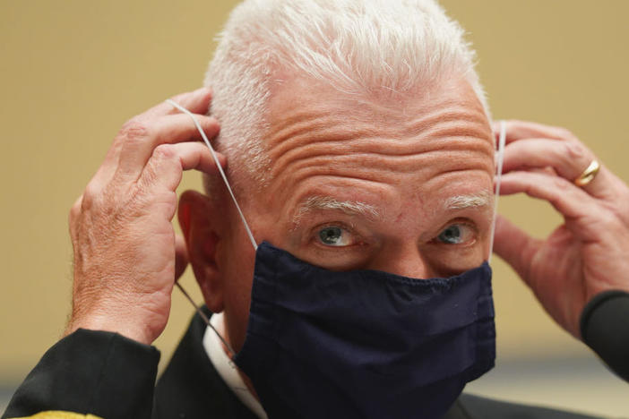 Adm. Brett Giroir, assistant secretary for health in the Department of Health and Human Services, adjusts his face mask while testifying this month before a House subcommittee on the coronavirus crisis.