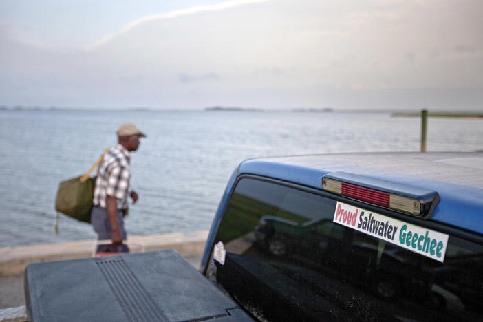 In this June 10, 2013 file photo, a sticker celebrating the Geechee heritage is seen on a pickup truck as passengers board a ferry to the mainland from Sapelo Island, Ga.