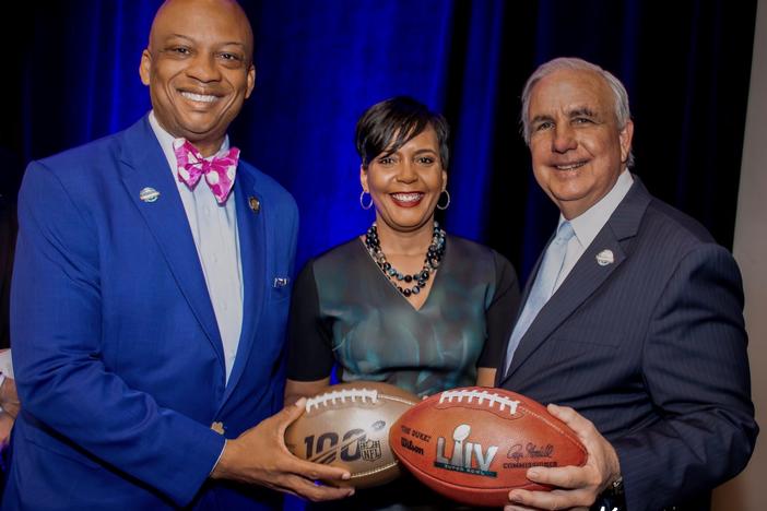 Oliver Gilbert (left) and Atlanta Mayor Keisha Lance Bottoms handoff the Super Bowl to Miami-Dade County Mayor Carlos Gimenez.