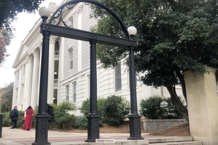 Students walk by the historic arches at the University of Georgia for what might be the last time in weeks due to COVID-19.