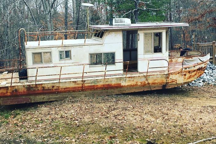 An abandonded houseboat, nicknamed "The Museum Houseboat," sits beached in a cove on Lake Lanier. In Feburary, two backhoes pulled the boat out of the cove and placed it on a flatbeat truck, where it was broken up.