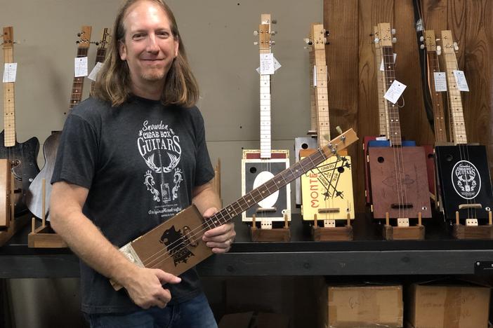 Mike Snowden in his Marietta home-based shop. He crafts and sells cigar box guitars.