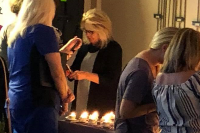 Jennifer Hodge lights candles Tuesday night at the second annual teacup memorial held at the University of North Georgia in Cumming.