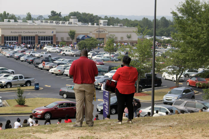Thousands of job hunters wait in a mile-long line along Eisenhower Parkway for a warehouse job fair in Macon.
