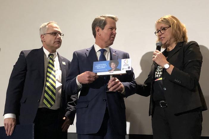 Jeff Breedlove (left) and Neil Campbell on Jan. 28, 2020, present Gov. Brian Kemp with a mini billboard from the Georgia Recovers campaign.