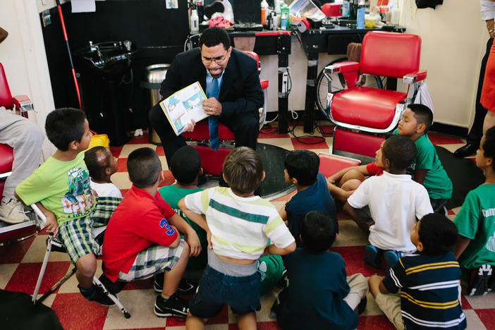 U.S. Education Secretary John King reads to a group of school-aged children. He recently advised governors and state school leaders to do away with corporal punishment.