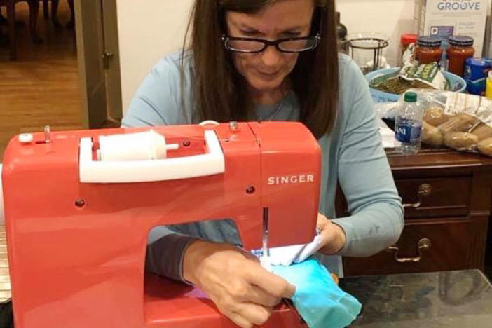 Leslie Owens sews together protective mask covers outof surgical linen in her Albany home. 