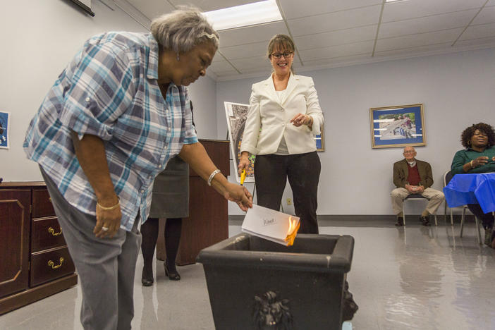Lillie Ward burns her mortgage in a ceremony at Macon Area Habitat for Humanity recently. 