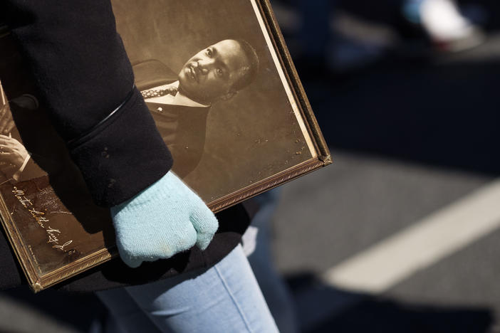 A marcher in Macon carries a framed photograph of Martin Luther King Jr.