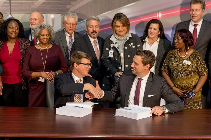 MARTA CEO Jeffrey Parker shakes hands with Stadler Rail CEO Martin Ritter. MARTA will purchase 254 new rail cars. 