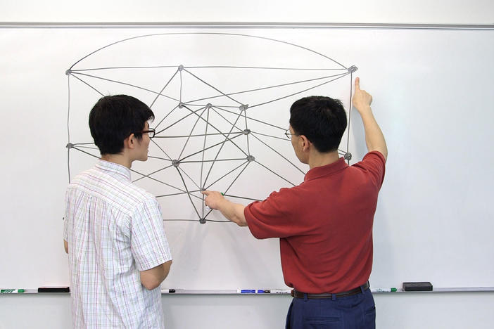 Yan Wang (left) and Xingxing Yu (right) at the whiteboard.