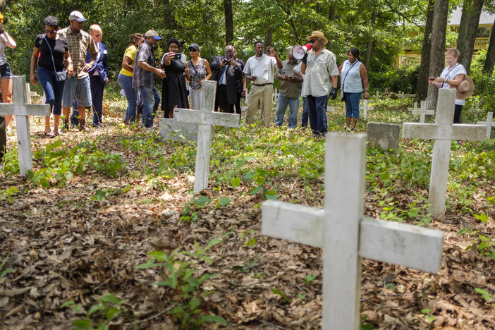 Tyrone Brooks leads a tour through a cemetery of anonymous graves surrounded by an office park to a marker for 1946 lynching victim Mae Murray Dorsey.
