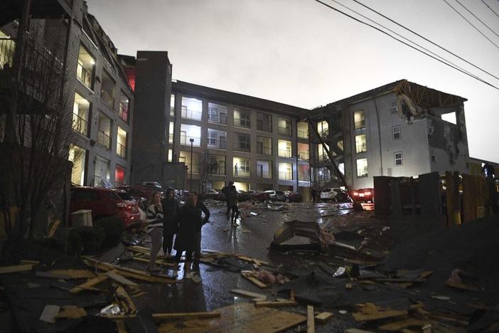 Debris is scattered across the parking lot of a damaged apartment building after a tornado hit Nashville in the early morning hours of Tuesday, March 3, 2020.