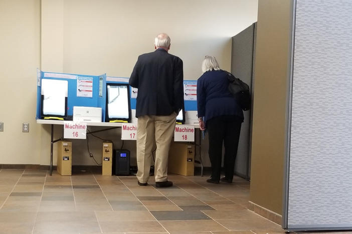 Richard DeMillo and Marilyn Marks look at a Dominion ballot-marking device at a voting precinct in Paulding County on Nov. 5, 2019.