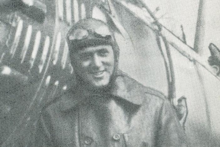 Roland Neel of Macon, Georgia in his flight outfit, standing in front of his plane [undated).