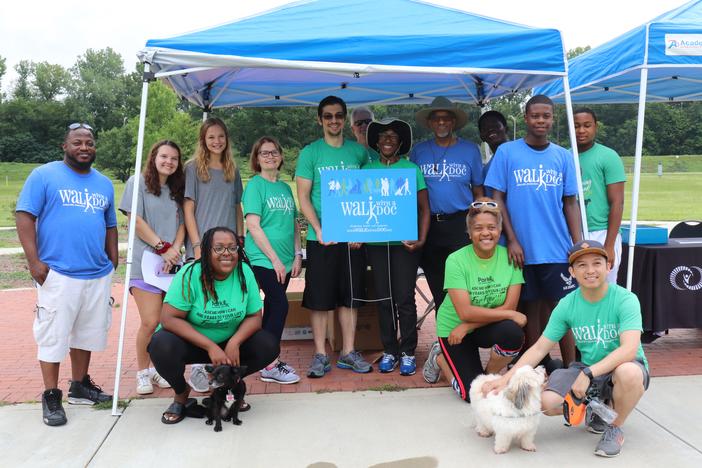 Nancy Cleveland (front left), Dr. Harry Strothers, nurse researcher Mary Hoey and a group of participants pose by the Walk With A Doc tent in Macon's Central City Park on Saturday, July 6