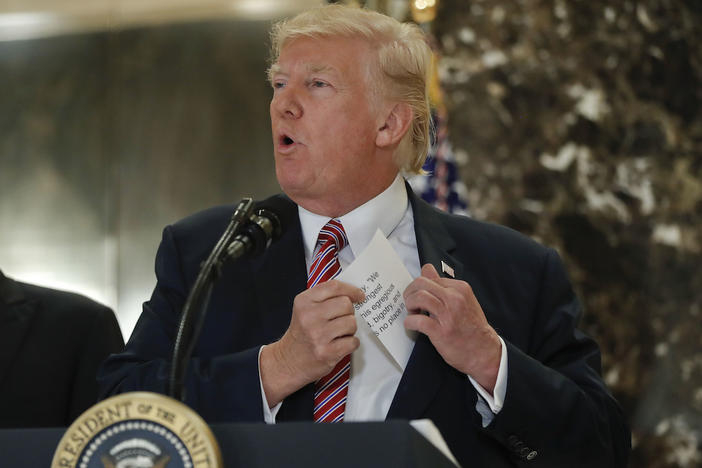 President Donald Trump reaching into his suit jacket to read a quote he made on Saturday regarding the events in Charlottesville, Va., as he speaks to the media in the lobby of Trump Tower, Tuesday, Aug. 15, 2017.