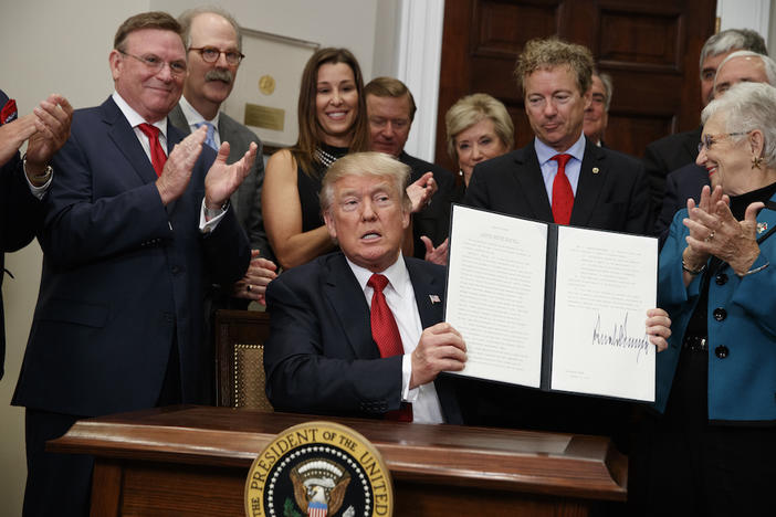 President Donald Trump shows an executive order on health care that he signed in the Roosevelt Room of the White House, Thursday, Oct. 12, 2017, in Washington.