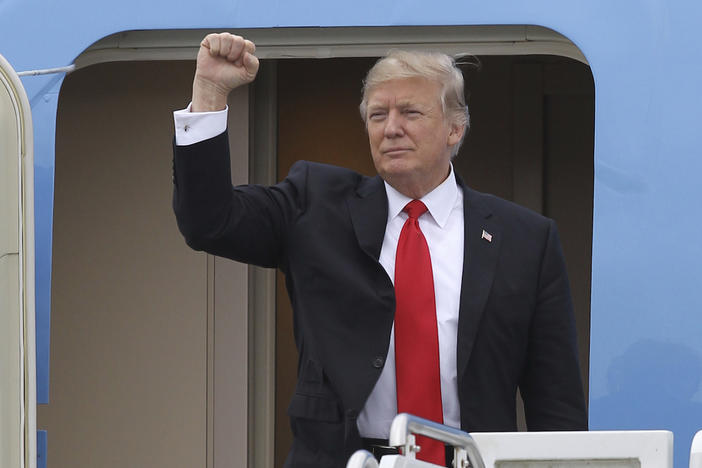 President Donald Trump gestures from the stairs of Air Force One upon his arrival at Palm Beach International Airport in West Palm Beach, Fla. Friday, March 3, 2017.