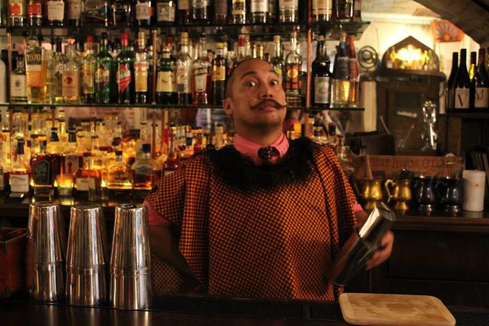A costumed bartender mixes a drink at the American Prohibition Museum bar. 