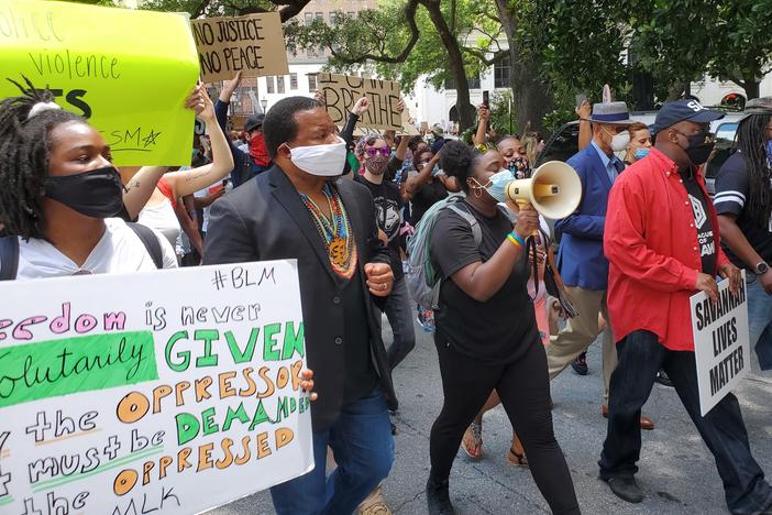 Savannah organizers Faith Harris (left) and Nychorida Austin (with bullhorn) lead a protest march flanked by New Georgia Project chairman Francys Johnson, Savannah Mayor Van Johnson (right, in red) and former Mayor Otis Johnson (right, in blue).