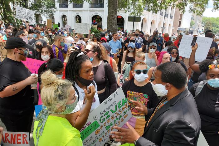 Local organizers including Faith Harris, center, discuss the gameplan for a protest march in Savannah with veteran Georgia civil rights leader Francys Johnson, right.
