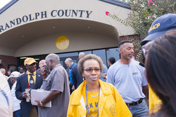 Opponents to the plan to shutdown seven of nine polling places in Randolph County wait to get into the government center for the vote on the plan Friday morning.