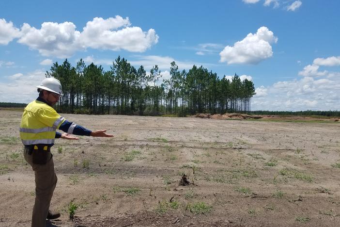 Jim Renner of Southern Ionics Minerals explains the post-mining reclamation process. This area has had its topsoil replaced and will be planted with loblolly and slash pine in the winter. In the distance is a wetland area the mine avoided.
