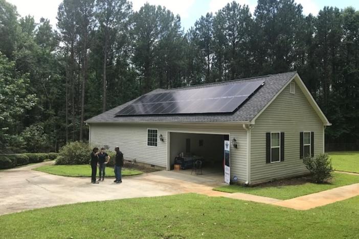 L-R Homeowner Eric Byas and Chaia Lews with Creative Solar talk to one of Byas' neighbors about residential solar power.