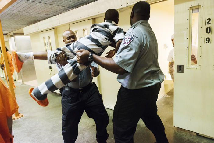 A nine-year-old boy is lifted and forced through a cell door at the Bibb County Jail during the Consider the Consequences youth intervention program recently. 