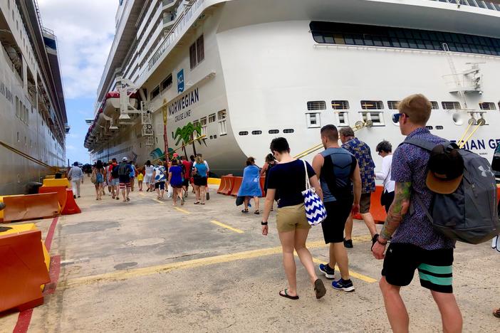 Passengers line up to board a Norwegian Cruise ship.  