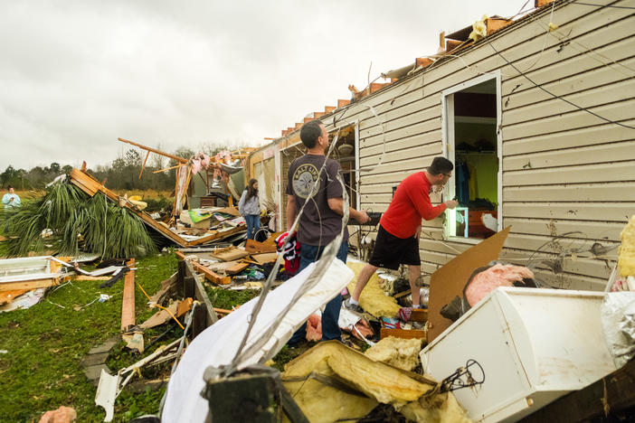 Neighbors look through a home just north of Fort Valley in Crawford County, destroyed by a tornado Sunday night. 