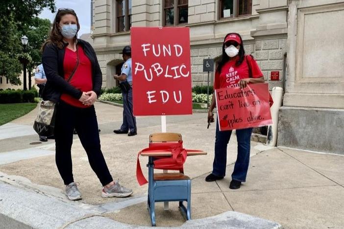 Teachers stand in from of the Capitol to talk to lawmakers about proposed budget cuts to education.