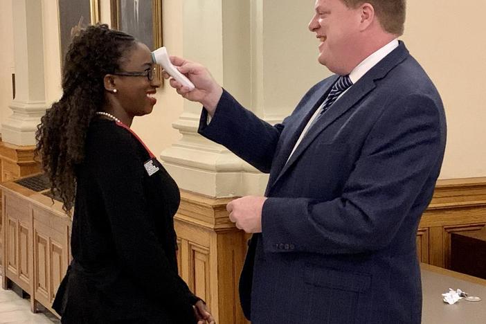 At the Capitol, Rep. Dar'shaun Kendrick has her temperature taken before the start of the special legislative session to approve the governor's declaration of a public health emergency.