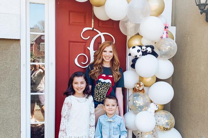 A family poses in front of their zoo-themed door to help bring happiness to fellow neighbors.