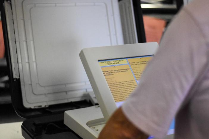 An elections worker in Fayette County prepares a voting machine for testing on Sept. 24, 2018