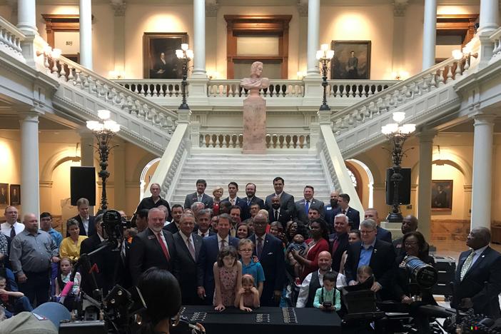 Gov. Brian Kemp, Micah Gravley and other state officials celebrate after the signing of House Bill 324. The bill gives patients more access to medical marijuana. 