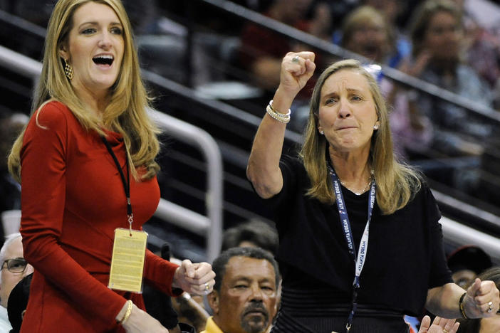 Kelly Loeffler (left), with Mary Brock, cheers the Atlanta Dream on courtside during a 2011 game. Now a senator, Loeffler faces a political challenge over her stake in the WNBA franchise in a tough election race.