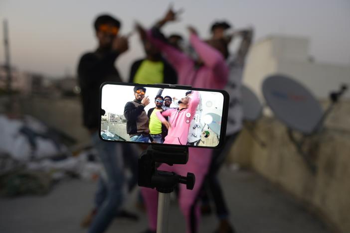 Youths perform in front of a cellphone camera while making a TikTok video on the roof of their residence in Hyderabad, India, in February. India's government has banned 59 Chinese-owned apps including TikTok.