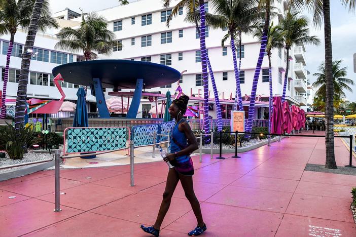 A woman walks past a closed restaurant this week in Miami Beach, Fla., during the coronavirus pandemic.
