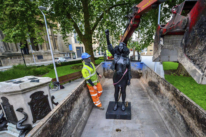 Contractors on Thursday remove Marc Quinn's statue, <em>A Surge of Power (Jen Reid) 2020</em>, after its temporary stint atop the plinth dedicated to slave trader Edward Colston in Bristol. Officials in the British city said the sculpture had been set up without their permission.