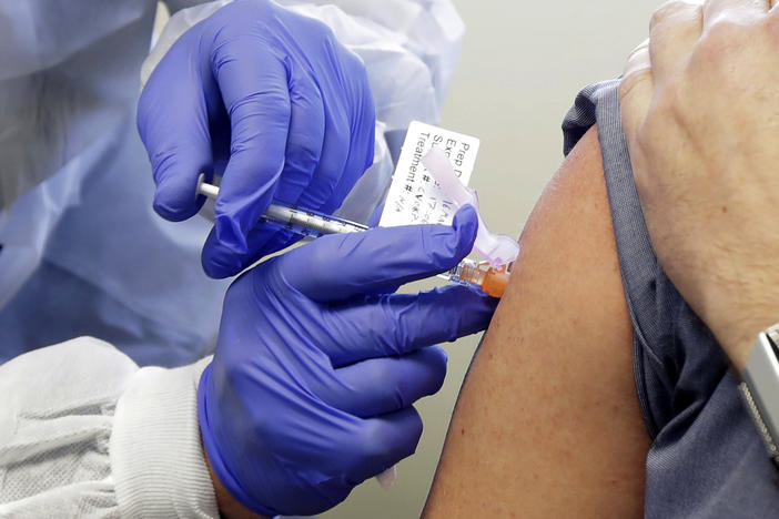 A volunteer receives a shot in a clinical trial for a potential coronavirus vaccine. U.S. intelligence officials say Russian hackers are attempting to break into U.S. health care organizations working on a vaccine.